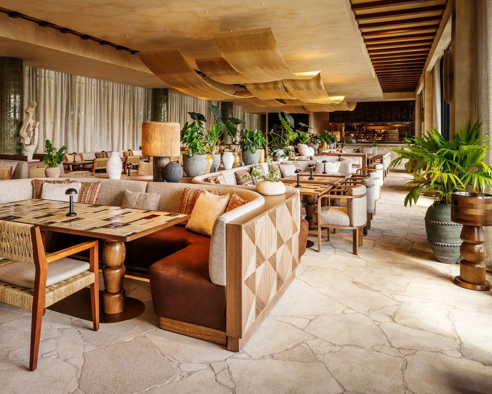 Casa Neos Restaurant dining room with draped ceiling, banquette seating, and stone flooring